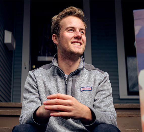A woman in sunglasses claps in a crowd at a basketball game